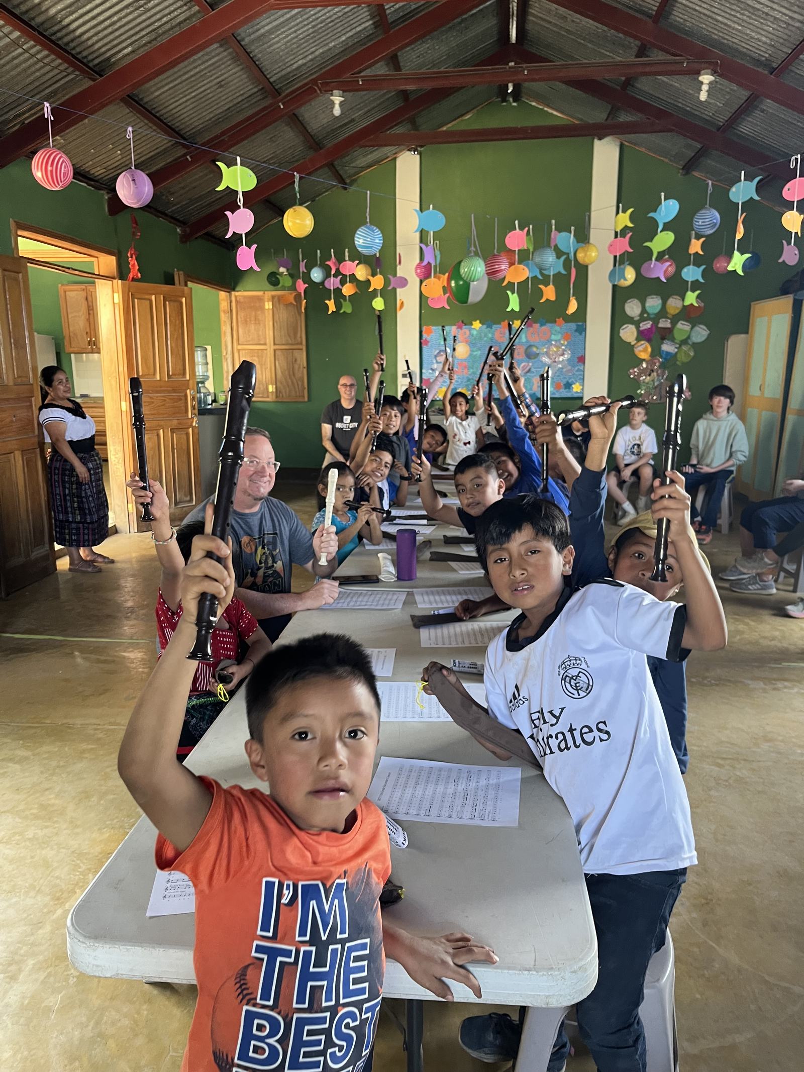 kids waving from a table, balloons, aleluya